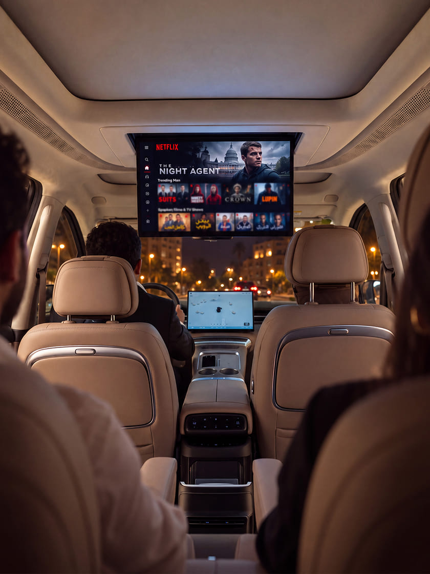 Passengers watching the ceiling screen of an XPENG X9 while the chauffeur drives at night